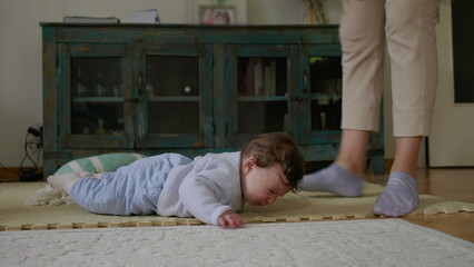 Baby being gently picked up from mat after tactile playtime, transitioning from independent...