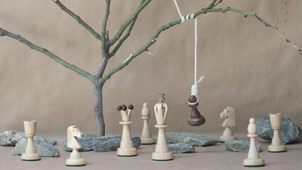 chess piece black pawn hanging on noose among white chess pieces
