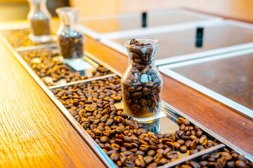 Spilled roasted coffee beans in glass cups on the counter