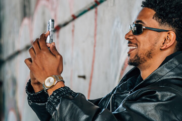 young man urban style on the street with mobile phone or smartphone