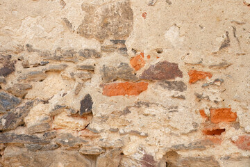 Old crumbling stone and brick wall texture
