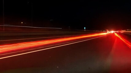 Long Exposure Night Photography Capturing Speed and Motion of Vehicles on Urban Highway with Vibrant Light Trails on Asphalt Road