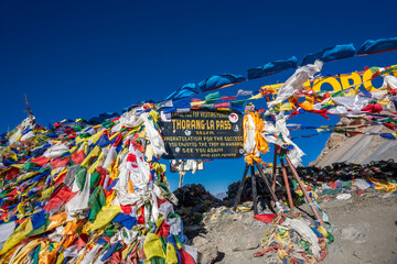 The waving prayer flags at the top of Thorung La Pass, the highest point of the Annapurna Circuit Trek in Himalaya mountains, Nepal.