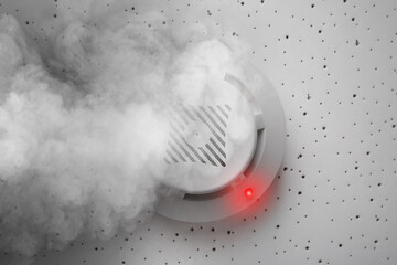 Fire alarm system detector on ceiling triggered by smoke, bottom view