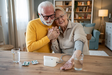 Senior couple measuring blood pressure at home together