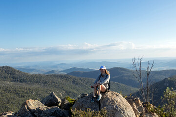 Woman Hiking at Booroomba Rocks Lookout, Namadgi National Park, ACT – Scenic Granite Cliffs and Mountain Trail Adventure at Sunset