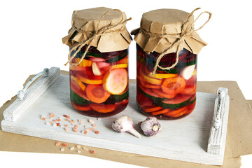 two glass jars with various fermented vegetables on white wooden tray