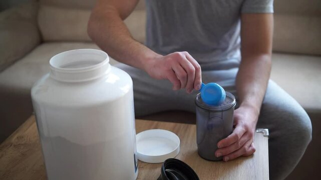 Scooping whey protein from a plastic jar
