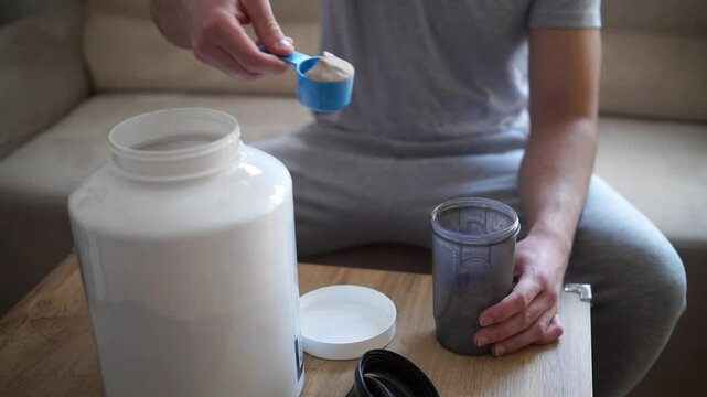 Scooping whey protein from a plastic jar