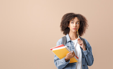 Fototapeta premium Serious question and making decision studying after quarantine. Pensive african american lady with smart watch holds notepads and press pencil to cheek and looks at free space, on light background