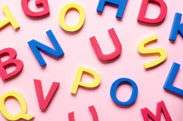 Colorful foam letters on pink background.