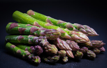 Fresh asparagus spears and sliced avocado arranged on a wooden surface natural and wholesome.