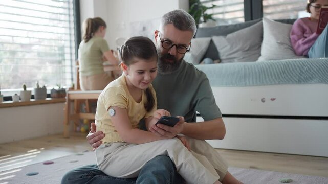 Diabetic girl with a CGM sensor on her arm.