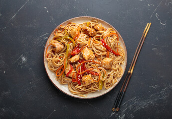 Delicious udon noodles stir fried with chicken meat and vegetables, sprinkled with sesame seeds,...