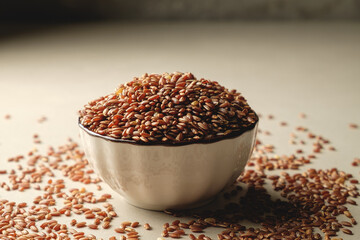 Organic brown rice nestled in a shining bowl surrounded by grains