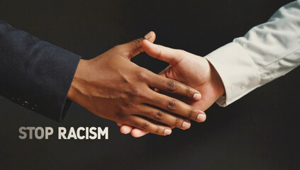 Hands of diverse individuals, one dark-skinned and one light-skinned, coming together in a handshake, symbolizing unity and collaboration against racism and discrimination