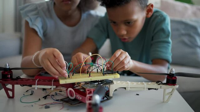 Kids building their first homemade robot at home.
