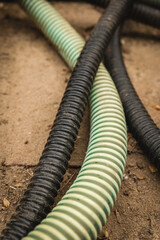 Colorful hoses intertwine on a dusty surface during outdoor maintenance activities
