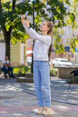 Young woman tourist trying to catch a communication signal and Internet on mobile phone, raised the...
