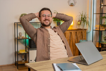 Fototapeta premium Happy Caucasian businessman closing laptop pc after finishing work. Man guy freelancer working online, remote job at home office table workplace. E-learning, browsing internet on notebook computer.