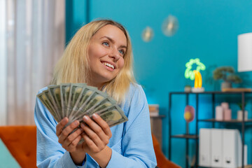 Smiling businesswoman counting cash money dollar checking salary enjoy richness at modern...