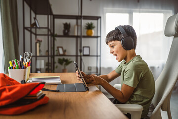boy with headphones use digital tablet at home, leisure activities