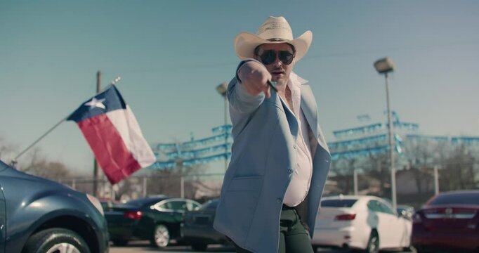 Car Salesman Wearing Cowboy Hat 
Pointing and Dancing At Car Dealership