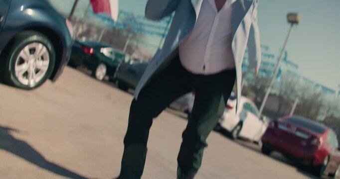 Car Salesman Wearing Cowboy Hat Dancing At Car Dealership