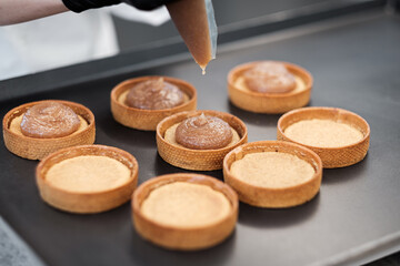 Creme Tarts Being Assembled by a Pastry Chef in a Gourmet Cafe