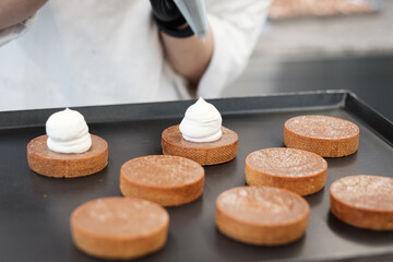 Creme Tarts Being Assembled by a Pastry Chef in a Gourmet Cafe