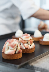 Fresh Fig Tarts Being Assembled by a Pastry Chef in a Gourmet Cafe