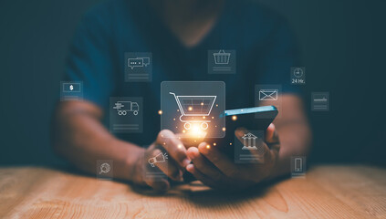 Ecommerce and online payment technology concept. Digital marketing. Businessman holding smartphone with shopping cart and business icon on virtual screen. Shopping online on internet network.