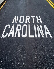 North carolina roadway text on asphalt surface with yellow lines