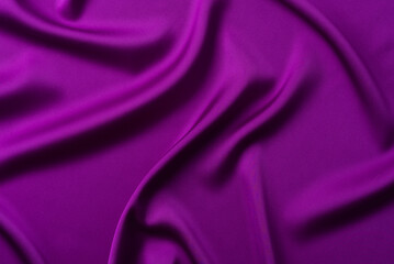 Abstract dark purple background. Deep violet silk satin fabric with soft wavy folds