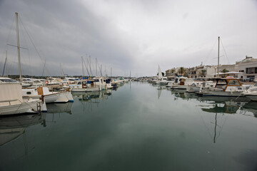 Fototapeta premium Sailboats and yachts reflecting on the calm water of portocolom, majorca, spain