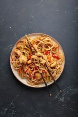 Delicious udon noodles stir fried with chicken meat and vegetables, sprinkled with sesame seeds,...