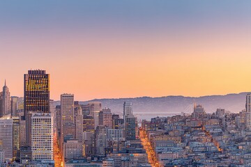 Fototapeta premium Stunning cityscape at sunset. Golden hour light bathes a vibrant city skyline, offering a captivating blend of urban architecture and natural beauty.