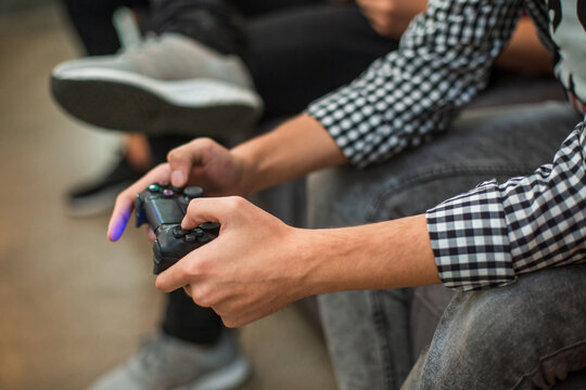 Hands holding video game controller in team play