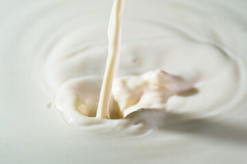 Close up shot of splashing fresh milk on container