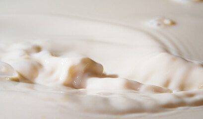 Close up shot of splashing fresh milk on container