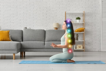 Pretty young woman doing breath practice on yoga mat at home
