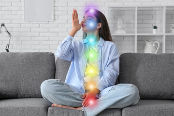 Beautiful young woman doing breath practice on sofa at home