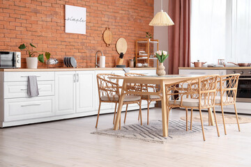Interior of modern kitchen with counters and dining table
