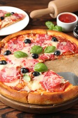 Tasty pizza and ingredients on wooden table, closeup