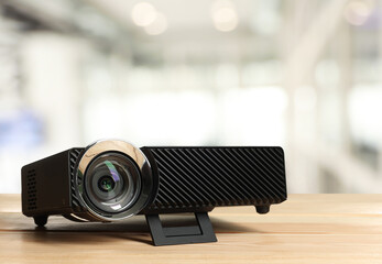 Modern video projector on wooden table in office