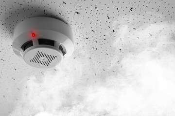 Fire alarm system. Detector on ceiling triggered by smoke