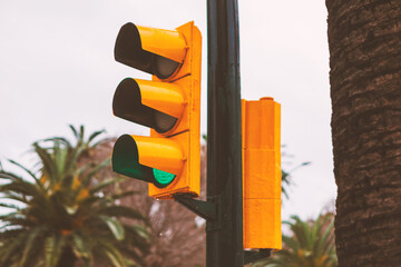 Vibrant yellow traffic signal, displaying a green light, indicates the safe passage ahead. Classic...
