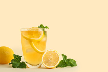 Glass of lemon ice tea with mint on beige background