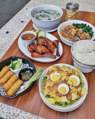 Various Asian dishes including fried chicken, spring rolls, vegetable soup and salad
