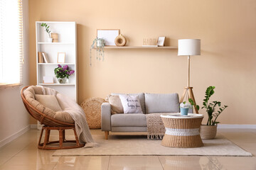 Sofa, armchair and coffee table near beige wall in interior of living room